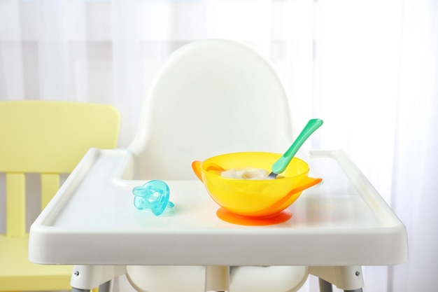 Kom met babyvoeding op kinderstoel binnen