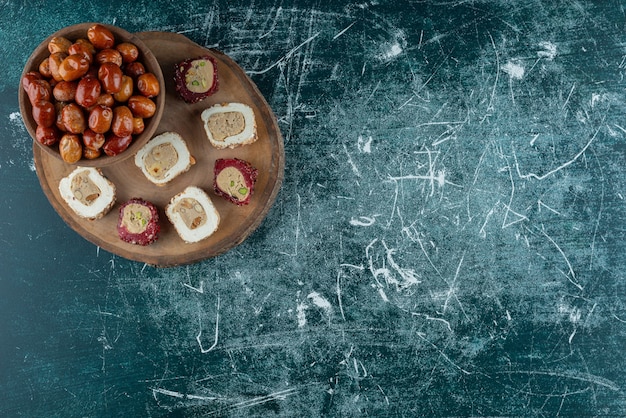 Kom met gedroogde dadels en zoete lekkernijen op een stuk hout.