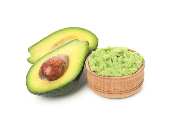 Kom met guacamole en avocado die op witte achtergrond wordt geïsoleerd