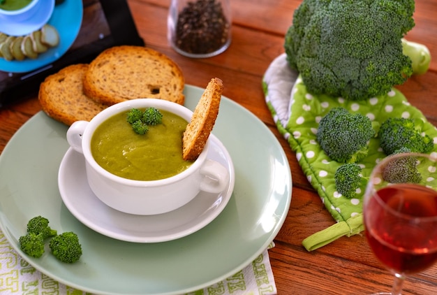 Foto kom met handgemaakte broccoli soep en croutons verse rauwe groene broccoli op een houten tafel