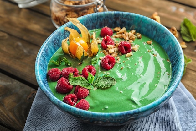 Kom met lekkere spirulina-smoothie op houten tafel Gezond veganistisch voedselconcept