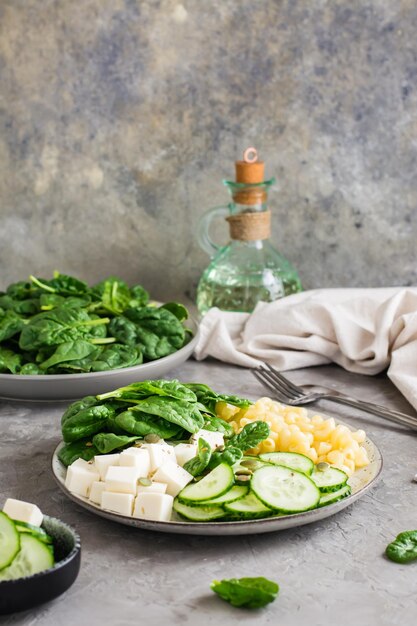 Kom met pasta, komkommer, kaas en spinazie op tafel Gezonde vitaminevoeding Verticale weergave