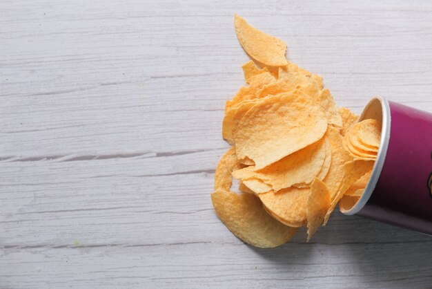 Kom met smakelijke chips op houten tafel.