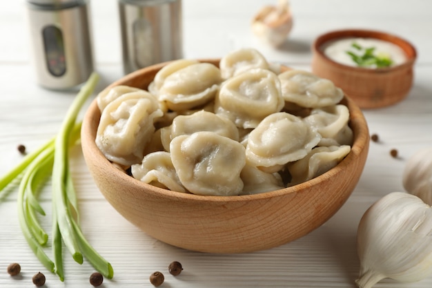 Kom met smakelijke dumplings en kruiden op houten