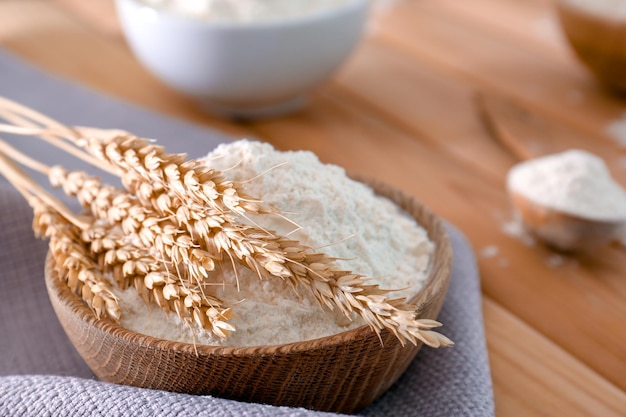 Kom met tarwemeel en spikes op houten tafel