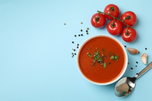 Kom met tomatensoep en ingrediënten op blauw