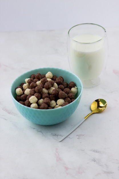 Kom met vanille en chocolade ballen op een witte achtergrond Snacks en een glas melk snel ontbijt
