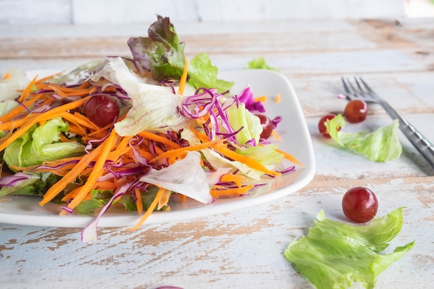 Kom plantaardige salade op houten lijst