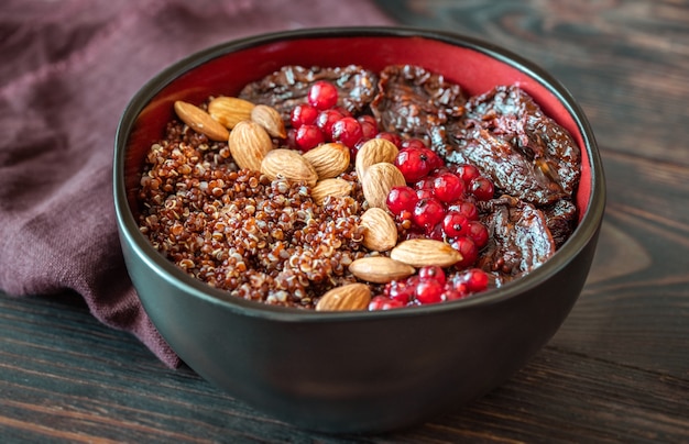 Kom rode quinoa met olijven, zongedroogde tomaten, bessen en noten