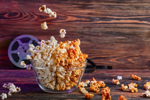 Kom smakelijke popcorn op houten achtergrond