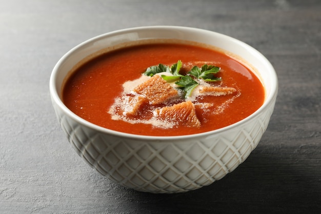 Kom smakelijke tomatensoep op donkere houten