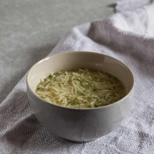 Kom soep van de kippennoedel. Eigengemaakte smakelijke Kippensoep in witte kom.