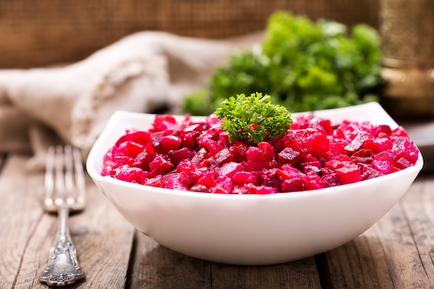 Kom traditionele Russische bietensalade vinaigrette op houten tafel