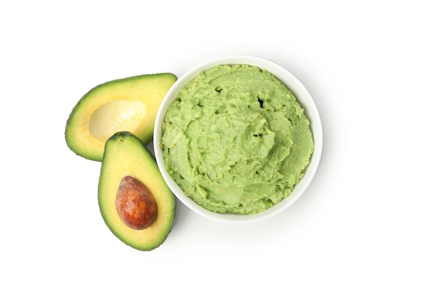 Kom van guacamole en avocado die op witte achtergrond wordt geïsoleerd