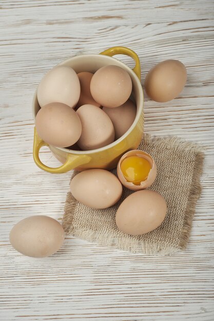 Kom van rauwe kippeneieren op de houten achtergrond