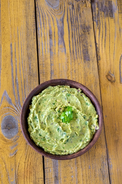 Kom verse guacamole op rustieke achtergrond