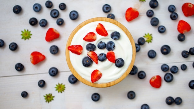 Kom vol aardbeien en bosbessen met yoghurt van bovenaf