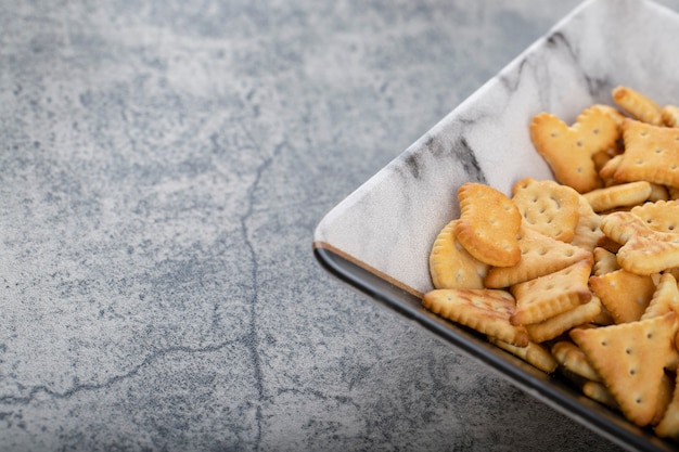 Kom vol knapperige crackers geplaatst op een stenen achtergrond.