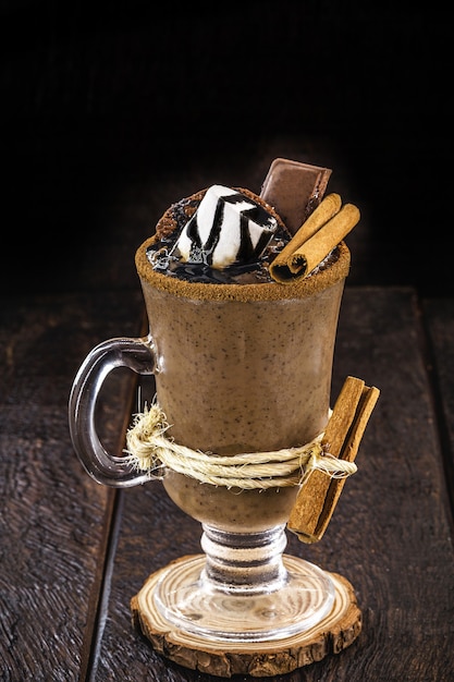 Kom warme chocolademelk met warme siroop, marshmallows, cacao en suiker. Zoete en warme winterdrank met zwarte achtergrond