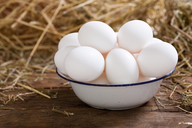 Kom witte eieren op een houten tafel