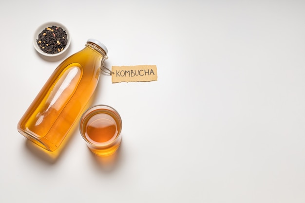 Kombucha bottle with "Kombucha" written on it and a glass of drink