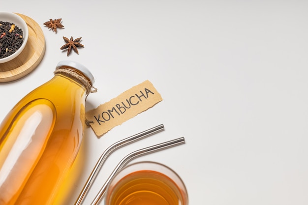 "Kombucha"라고 쓰여진 Kombucha 병과 음료 한 잔