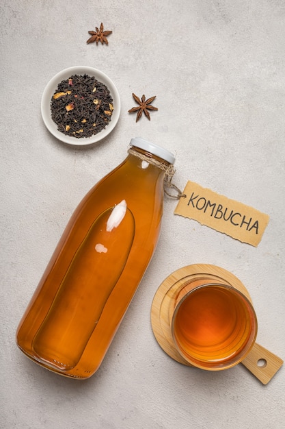 Kombuchafles met "Kombucha" erop geschreven en een glas drank