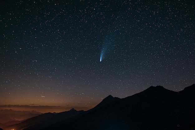 Komeet Neowise tweelingstaarten gloeien in de nachtelijke hemel. Telefotoweergave, details van de twee sterrensporen