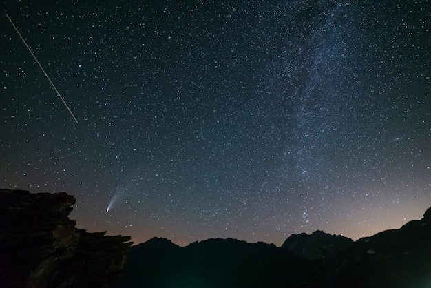 Komeet Neowise tweelingstaarten gloeien in de nachtelijke hemel. Telefotoweergave, details van de twee sterrensporen