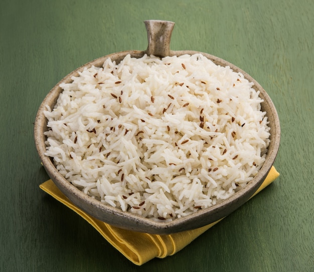 Komijnrijst of Indiase Jeera-rijst op kleurrijke achtergrond, selectieve focus