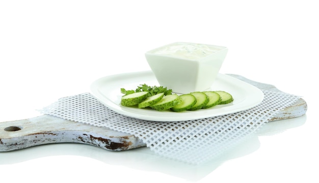 Komkommer yoghurt in kom op wit geïsoleerd op wit