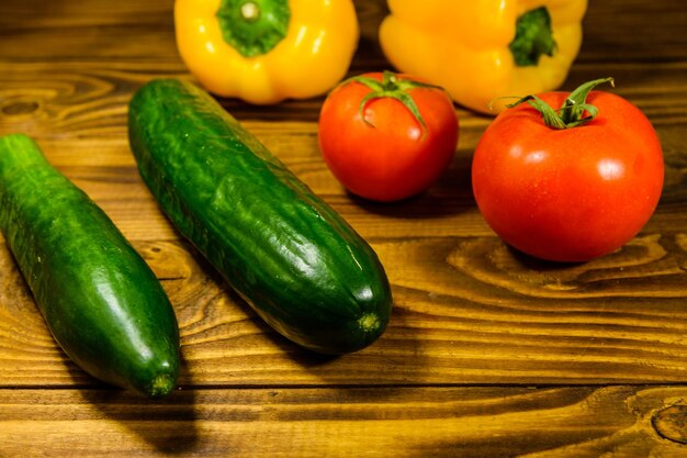 Komkommers, tomaten en paprika op houten tafel