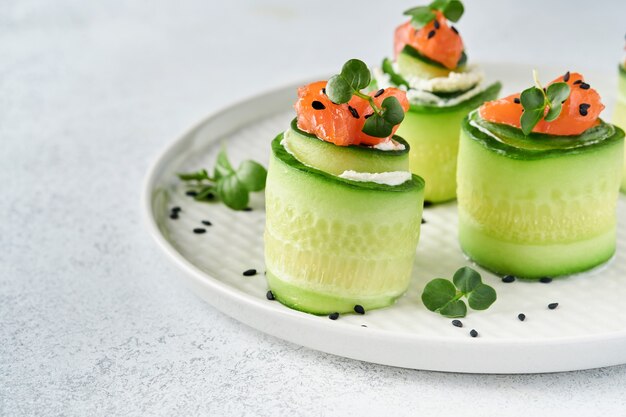 Komkommersrolletjes met zachte kaas, stukjes gezouten zalm