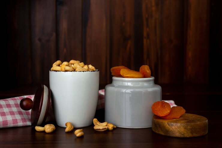 Kommen met cashewnoten en gedroogde abrikozen op houten tafel