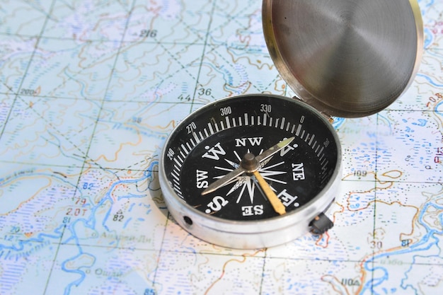 Foto kompas en kaart het magnetische kompas bevindt zich op een topografische kaart
