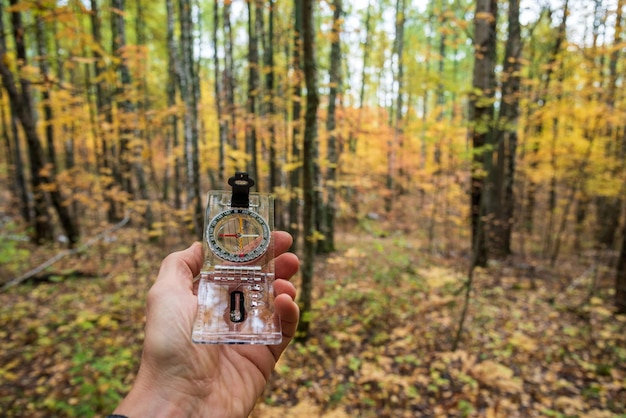 Kompas in de hand in het bos in de herfst selectieve focus