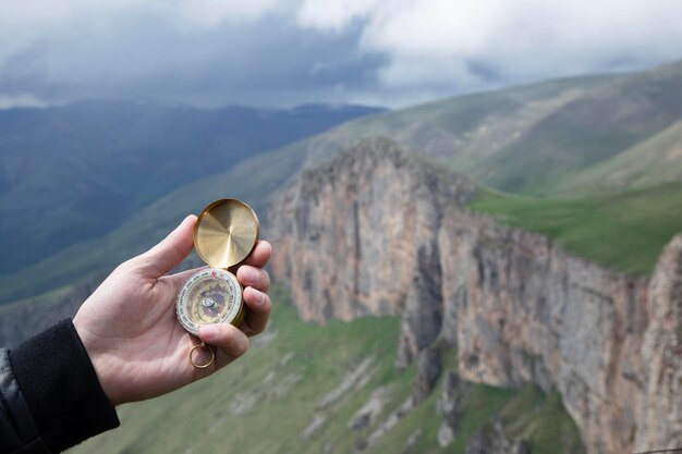 kompas in de hand van de mens op de bergtop kompas bovenop de berg