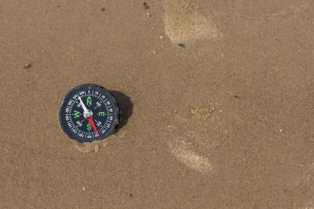 Kompas naar het zuidwesten liggend op zandstrand