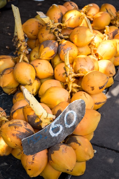 Koningsgele kokosnoten op takken in de markt