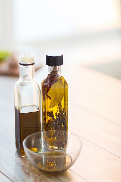 kook- en voedselconcept - close-up van twee olijfolieflessen en een kom met olie
