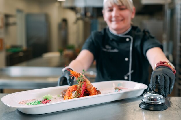 Foto kook met een kant-en-klaar gerecht met garnalen