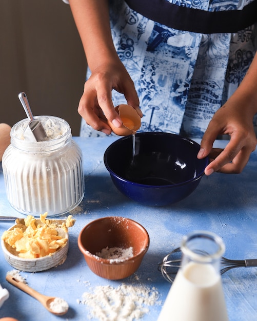 Kookproces voeg ei en bloem toe Vrouw Hand in de keuken met vintage schort