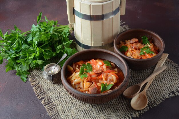 Koolstoofpot met gegrilde worst in tomatensaus