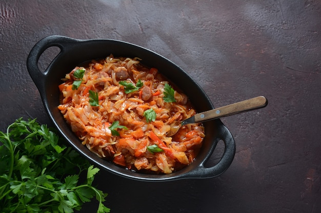 Koolstoofpot met gegrilde worst in tomatensaus