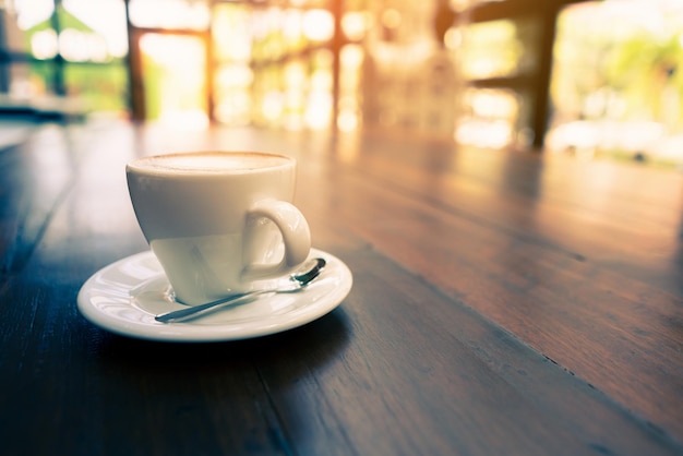 Kop cappuccino-koffie op houten tafel en vintage levensstijlchocolade op witte kop