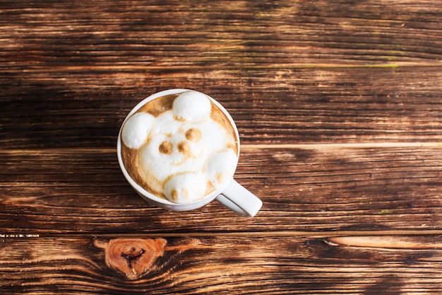 Kop cappuccino met latte art - 3d volume beer muilkorf op houten tafel