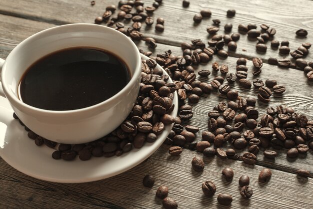 Kop koffie en bonen op houten oppervlakte