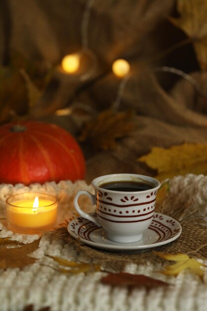 kop koffie op de herfst achtergrond met bladeren en kaarsen