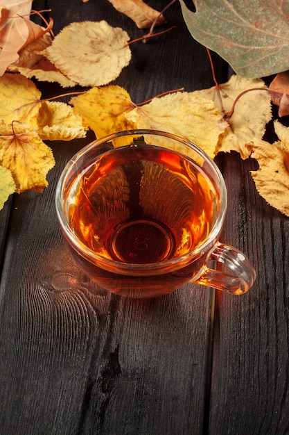 Kop thee en de herfstbladeren op de lijst