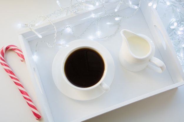 Kop van zwarte koffie en snoep riet op winter tafel